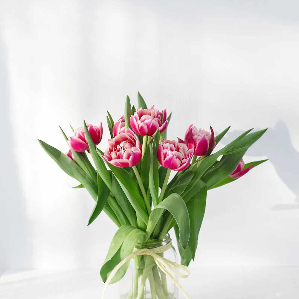 Fleurs roses dans un vase en verre